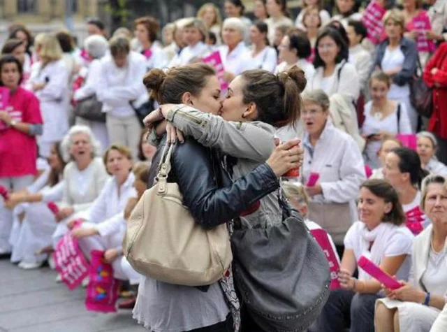 ImtiazMadmood's tweet photo. Two women kissing in front of an anti-gay parade. https://t.co/7eTUOpaaHB