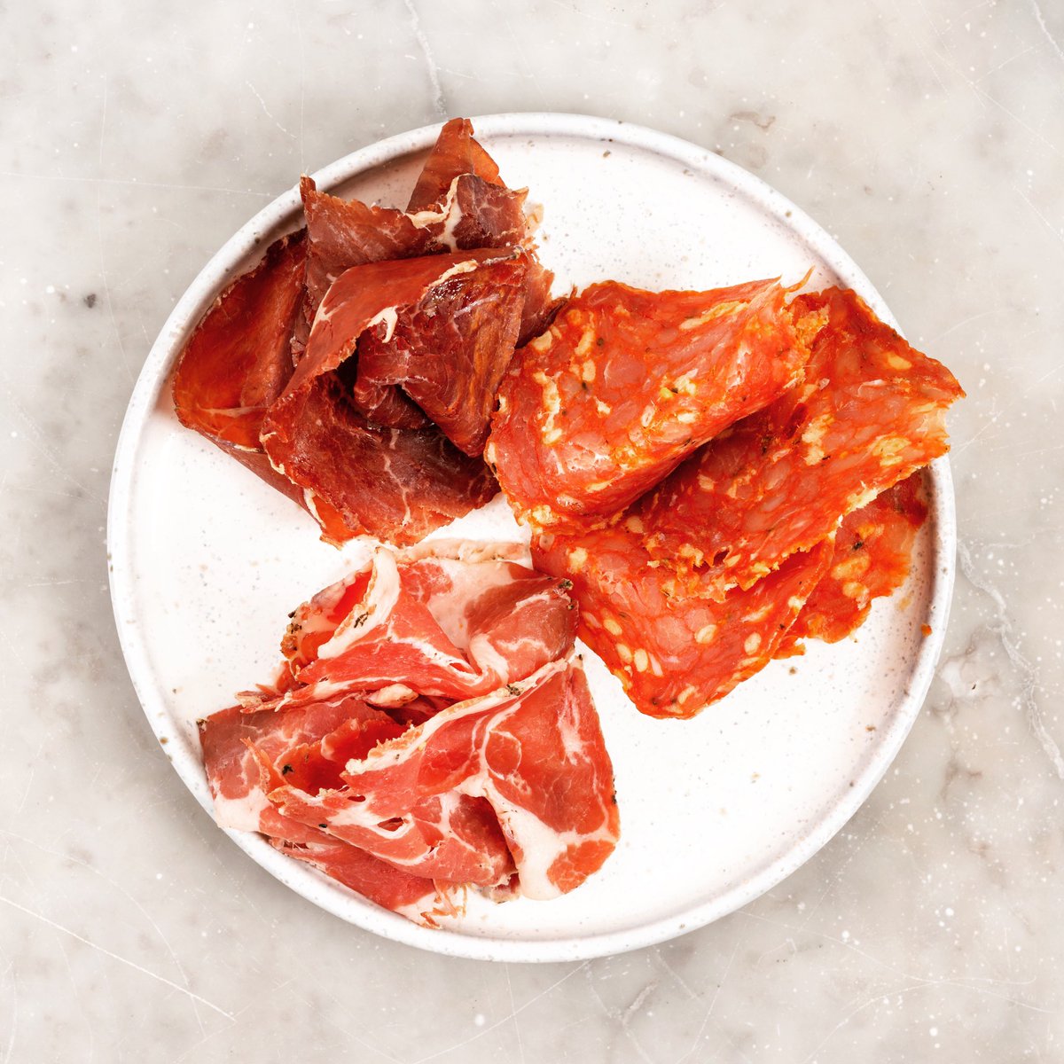 A little plate of our cured meats. Something to nibble on with an aperitif. Bresaola, Coppa &amp; oak-smoked Salami.