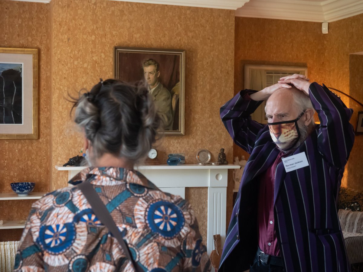 A Red House volunteer with hands on head talking to a visitor.