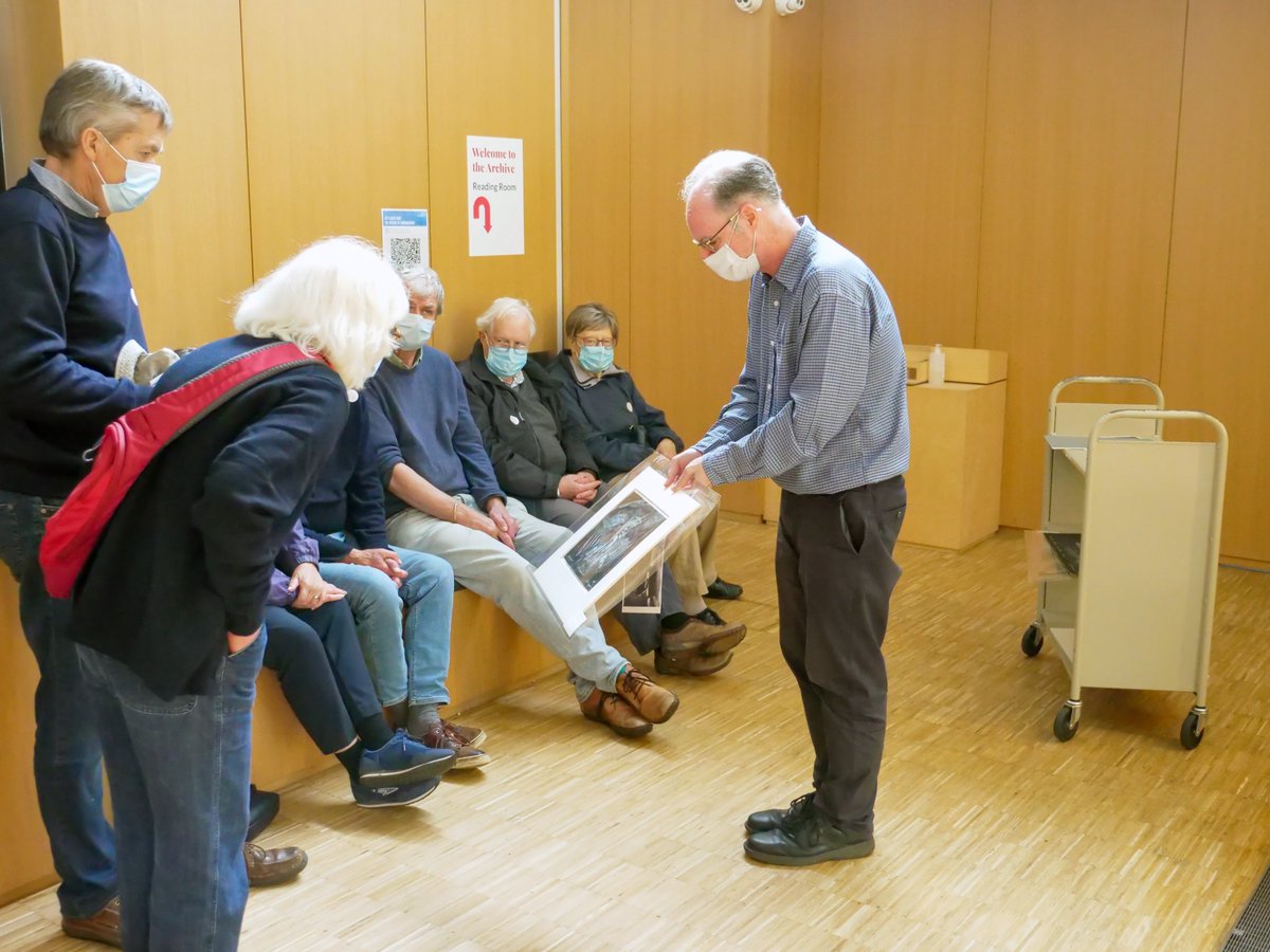 A group of people being shown an Archive item during an Archive talk