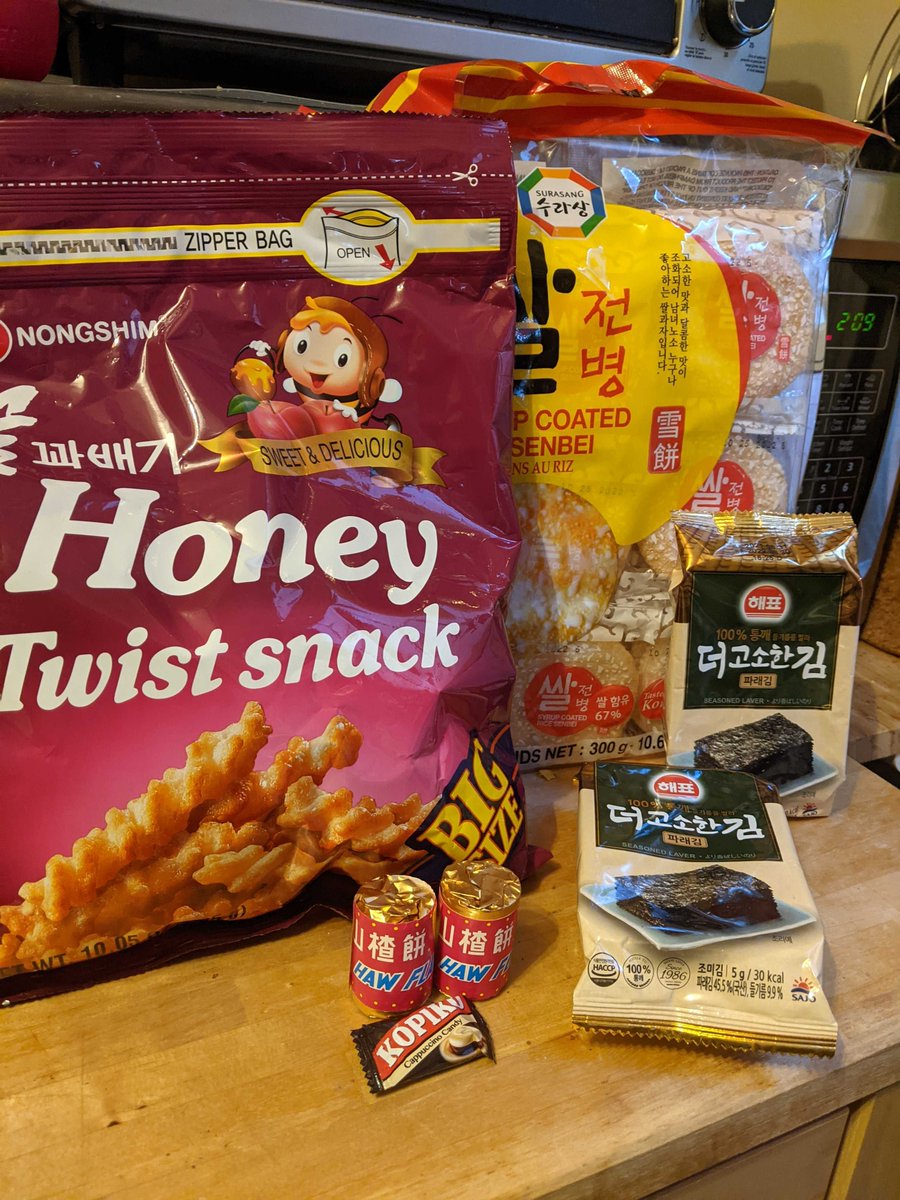 A photo with various asian snacks like dried seaweed, hawthorn candy and honey twist snacks.