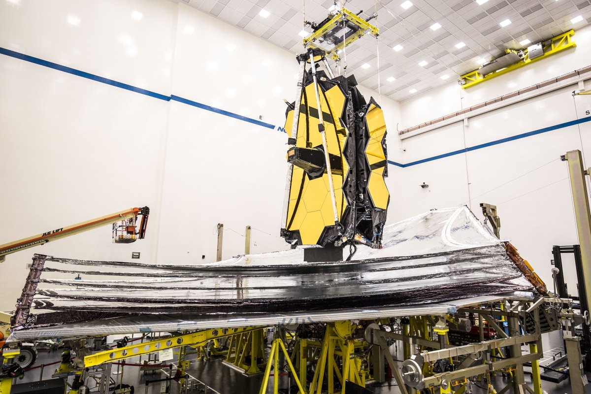 The James Webb Space Telescope with its fully deployed, silver kite-shaped sunshield inside the Northrop Grumman cleanroom