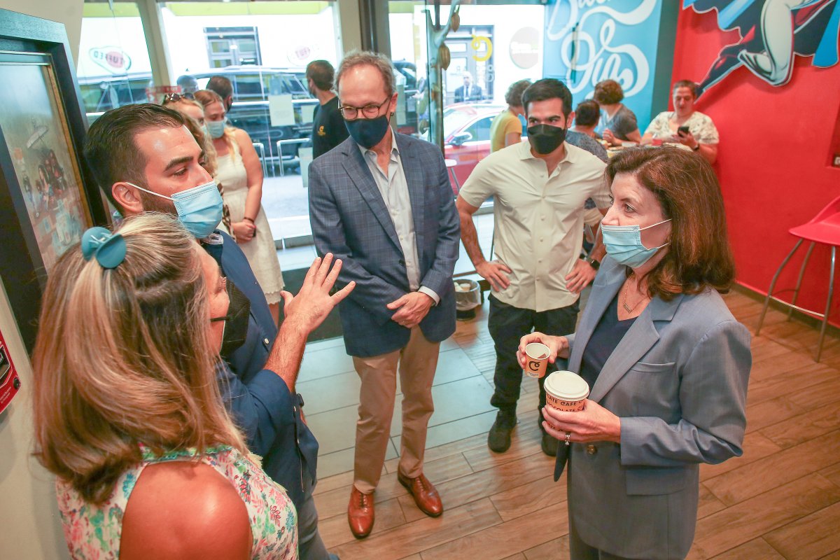 Group of five individuals wearing masked standing in a cafe