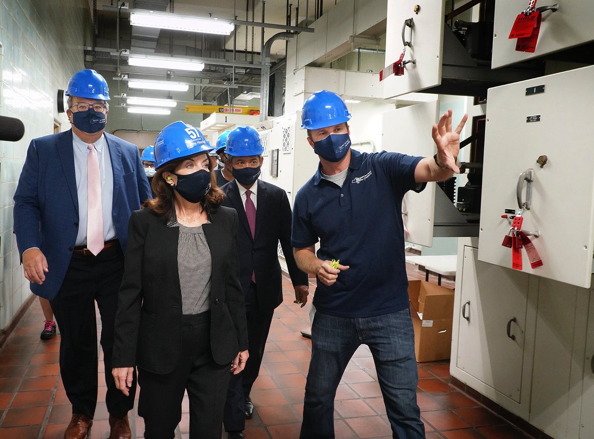 Governor Hochul stands with 3 people all wearing hard hats