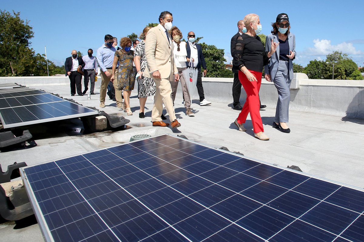 Group of people walk by solar panel