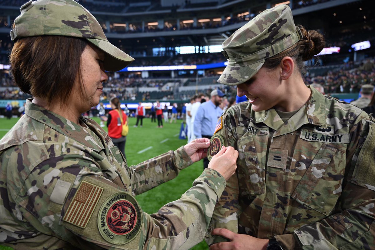 USAA's tweet photo. Twin sisters Emma & Aubrey Kuhrt were on the field representing West Point & the Air Force Academy during the football toss competition (Army won)! Afterwards CMSAF JoAnne Bass presented the pair with her patch! #ARMYvsAF https://t.co/euVCI63v9i