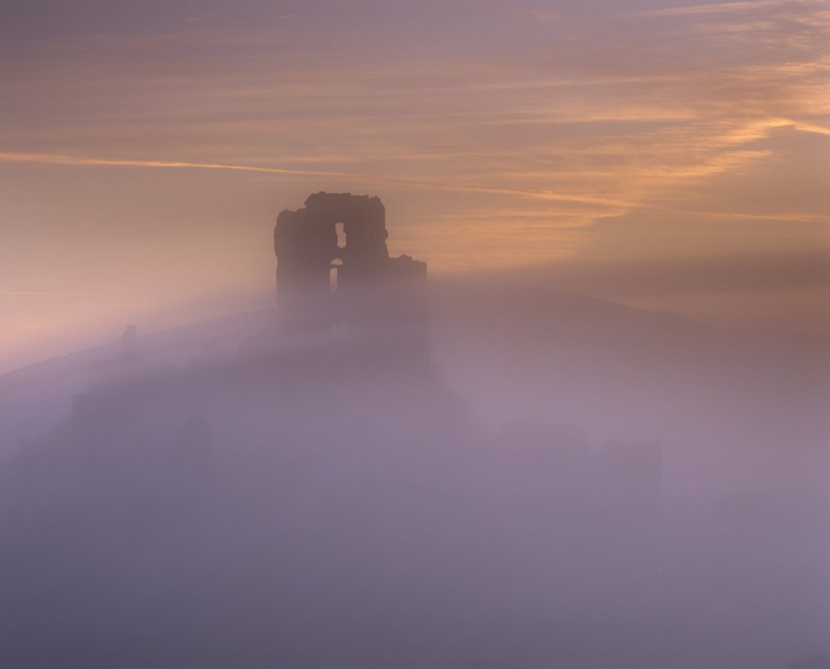 nationaltrust's tweet photo. The silhouette of a medieval castle emerges from the mist at dawn. Can you guess where it is? https://t.co/lgBUL753zd