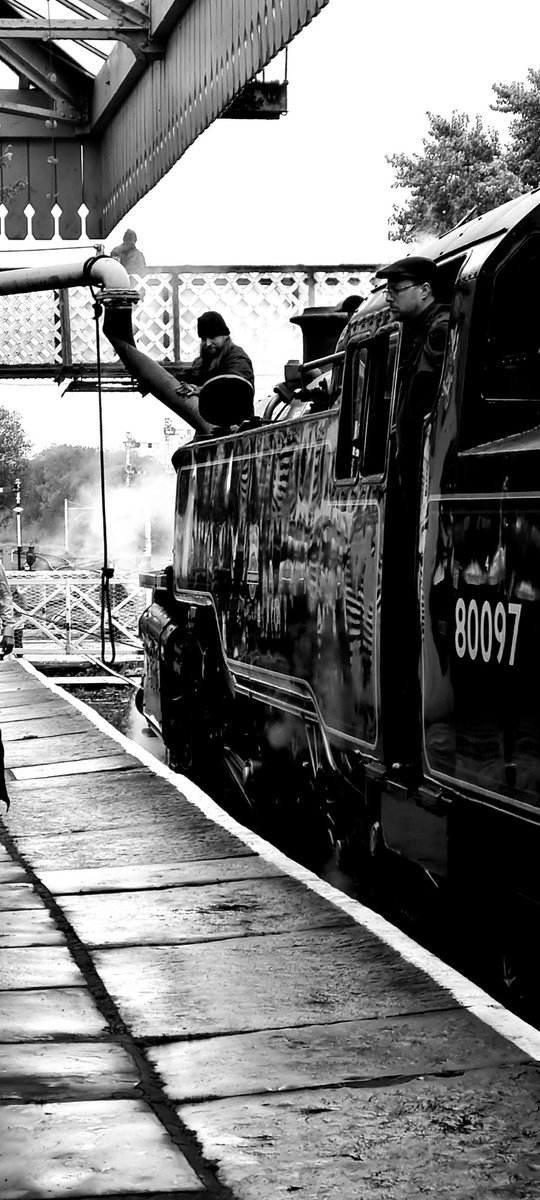 80087 stopping for water on a dull and wet Steam Gala day in Ramsbottom. Part of the East Lancs Railway Steam Gala. 17th October 2021.

#eastlancashirerailway #eastlancs #Steam #water #train #gala #train #locomotive #rain #wet #station #photography #blackandwhite