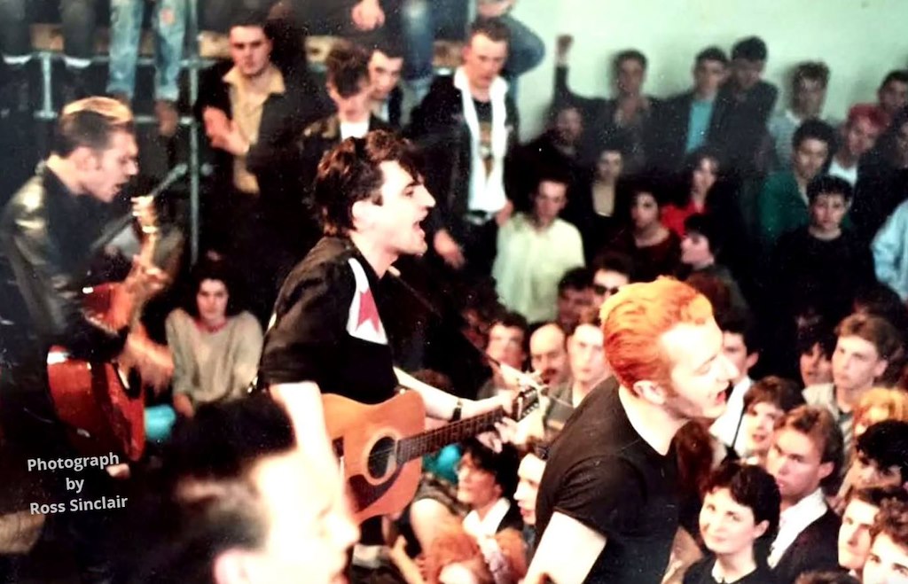kmcd_88's tweet photo. Picture by Ross Sinclair

We didn't have student cards so we couldn't go in, until Joe Strummer came out and says, "follow me" 
I walked through the crowd following Joe on to the stage, that's me in middle of photo wearing the white shirt

@NewWaveAndPunk
 @ScotsPostPunk https://t.co/z2D2J1kOD4