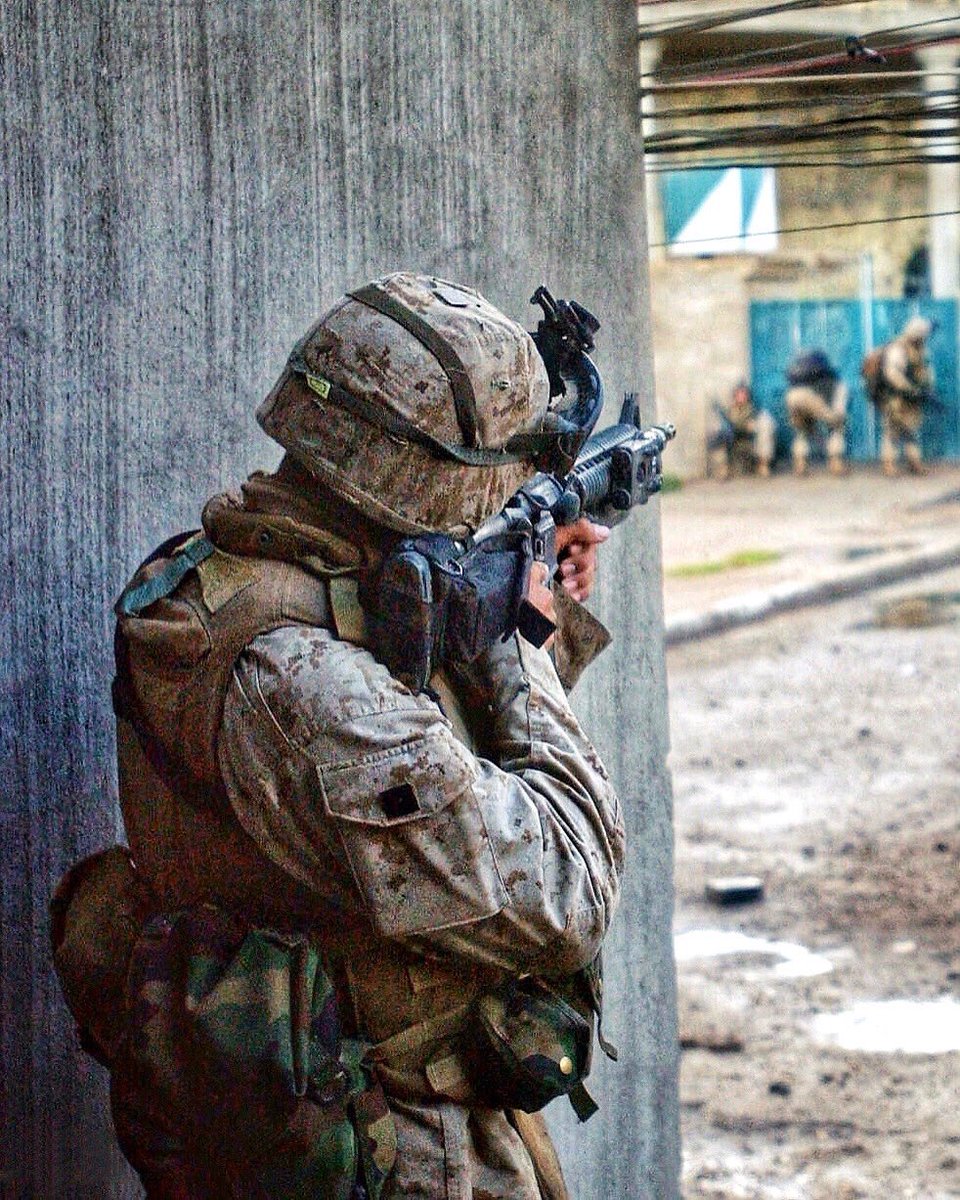 A U.S. Marine  from Bravo Company, 1/3, provides cover as members of his platoon advance down a street in the city of Fallujah, during Operation Phantom Fury on Nov 9, 2004. #USMC #fallujah #Military #History
