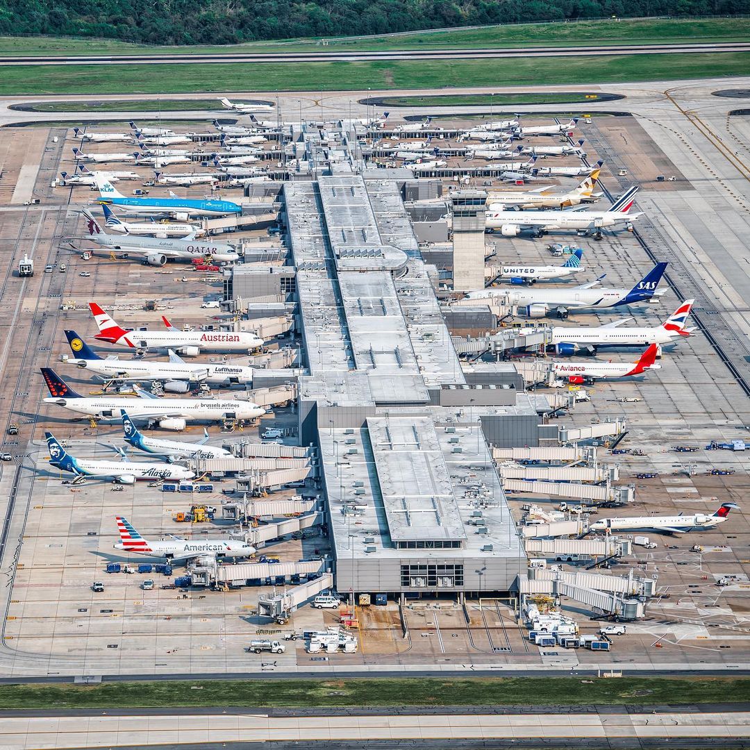 Image of Concourse A/B filled with planes from different countries sitting at their gates. Image taken via helicopter