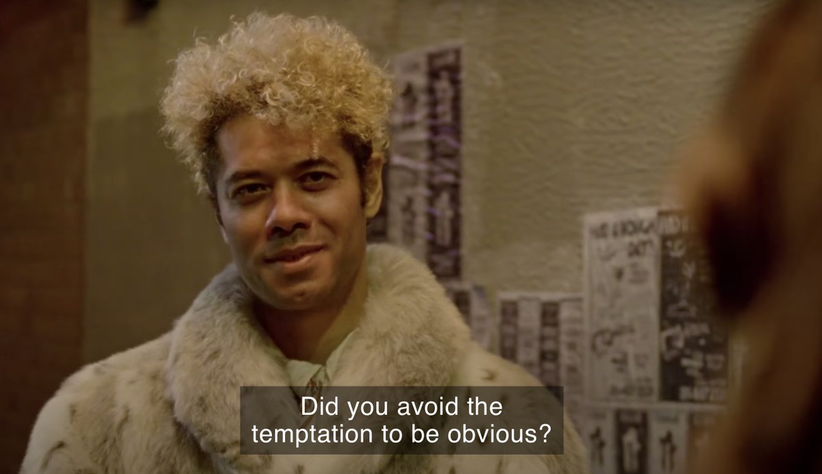 A man in an alleyway wearing a fur coat. Caption: "Did you avoid the temptation to be obvious?"