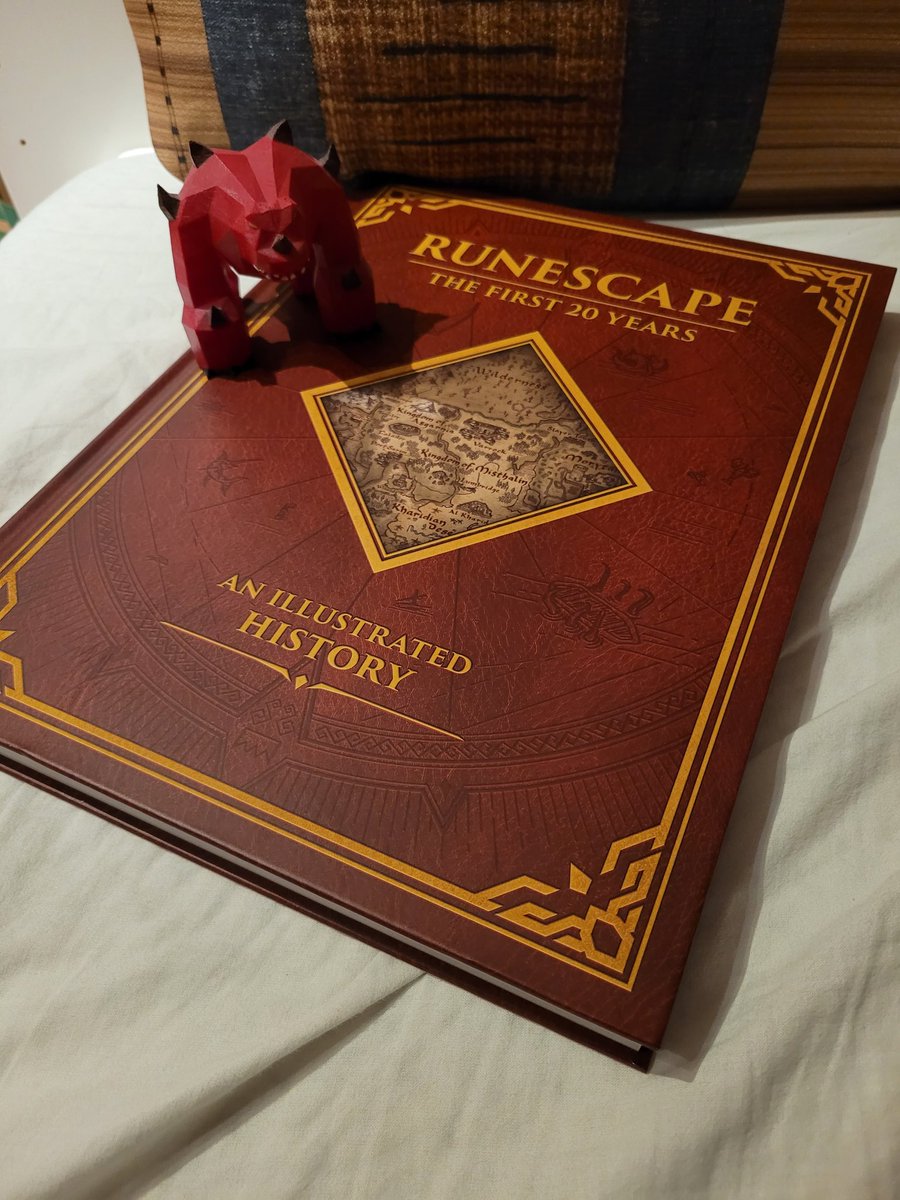 RsElej's tweet photo. He's guarding something! 
Oh, it's RuneScape: The First 20 Years book!!

Jad figure by @EstiOSRS

@RuneScape #RuneScape #20yearsofrunescape https://t.co/BJW5TbpHIz
