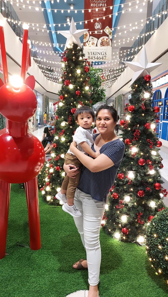 oelhyo's tweet photo. @smsupermalls #ChristmaSayaAtSM #TogetherAtSM 

@smsupermalls Finally were out and about SM BF mall! My quarantine baby is still adjusting to crowds, had to take this pic to mark this special day regardless. Is it just me or this Christmas centerpiece made us look extra beaming?! Loveee! 💕 https://t.co/tRn8OkJT7E