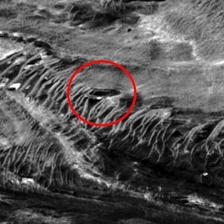SecureTeam10's tweet photo. Here's what's been described as a half mile wide shiny metallic "disc" or alien base, complete with large dark windows wrapping around it, sitting on or embedded into the edge of a cliff on planet Mars.. The NASA image was discovered in 2015 by Scott Waring of UFO Sightings Daily https://t.co/PYYkZsaBFG