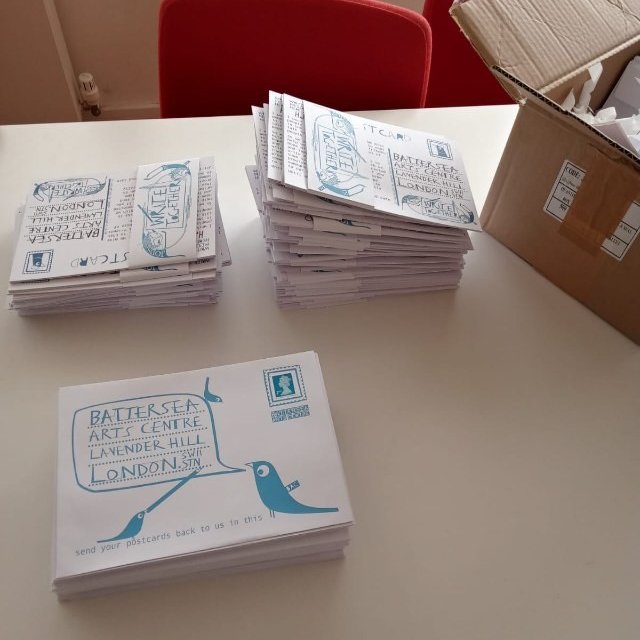 3 piles of blue & white Write Together envelopes next to a large brown box.