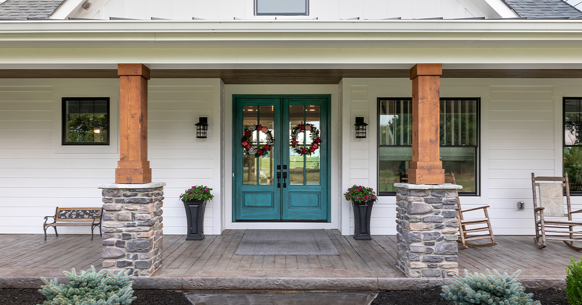 Many clients come to us for our popular farmhouse design custom homes. Front porch details on this farmhouse include the stone and wood columns, white lap siding, black window trim and lighting. Don’t you love the front door color?

Photo Credit: Greg Grupenhof