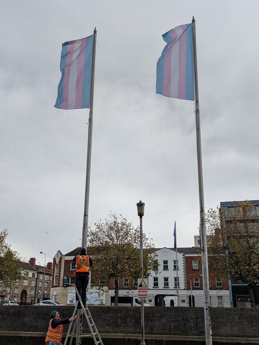 Two transgender flags (blue, pink, white) being raised along the Liffey by Dublin City Council for Transgender Awareness Week 2021.