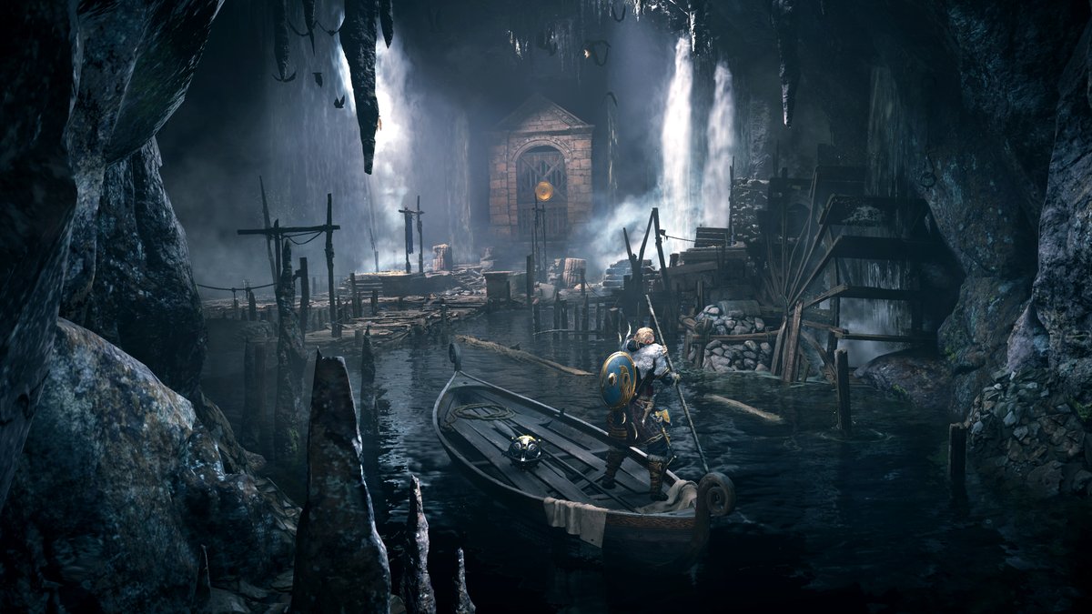 Eivor travels by boat through a dark cave. Jagged rocks give way to an old decrepit dock, where a foreboding gate with a golden seal awaits. 