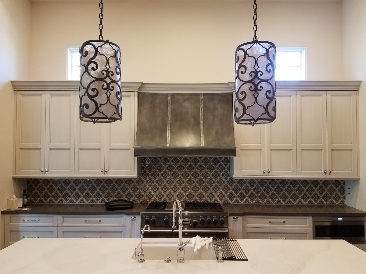 GrayleafStudio's tweet photo. Go bold. Be unique! 🌀⚔️ 

This antiqued zinc range hood unites the decorative chandeliers and mosaic backsplash, creating a one-of-a-kind kitchen space. 

https://t.co/UE0Od7LaKP https://t.co/KVFhNom5t2