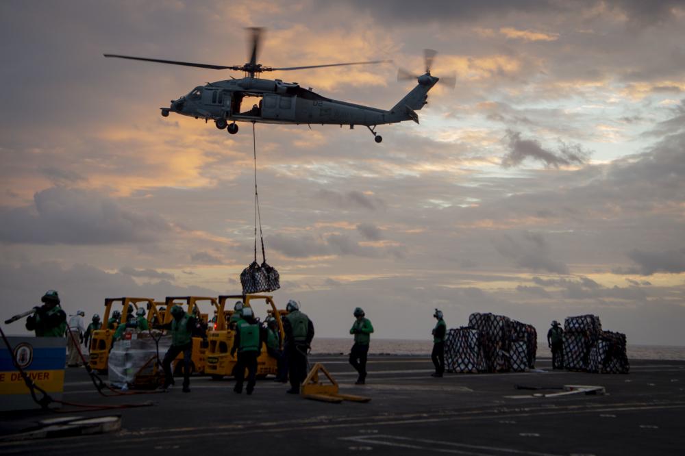 USPACOM's tweet photo. An MH-60S Sea Hawk, assigned to the “Island Knights” of Helicopter Sea Combat Squadron, transports supplies to @CVN70 during a vertical replenishment-at-sea with #USNSMatthewPerry. #FreeandOpenIndoPacific #PhilippineSea #Readiness https://t.co/PYk6S88sle