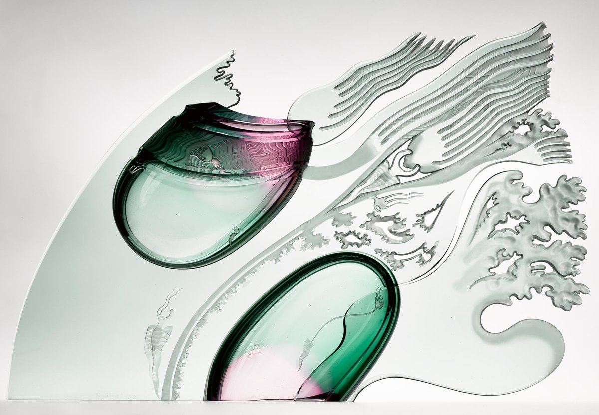 Delicately thin and smooth light green glass sculpture shaped like a breaking wave. Two deep green spheres sit within it, and fringed edges evoke the wind.