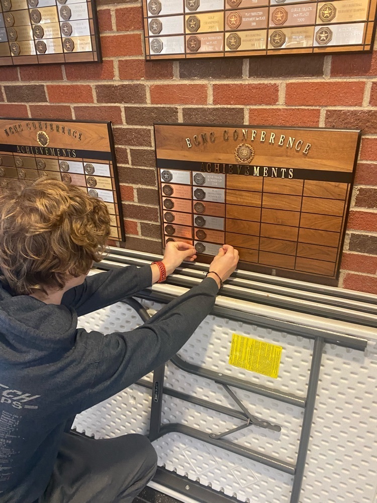 EMKnightsSchool's tweet image. Riley, the ECNC Conference’s Most Outstanding Actor, putting up the placard for our One Act’s Runner-up performance