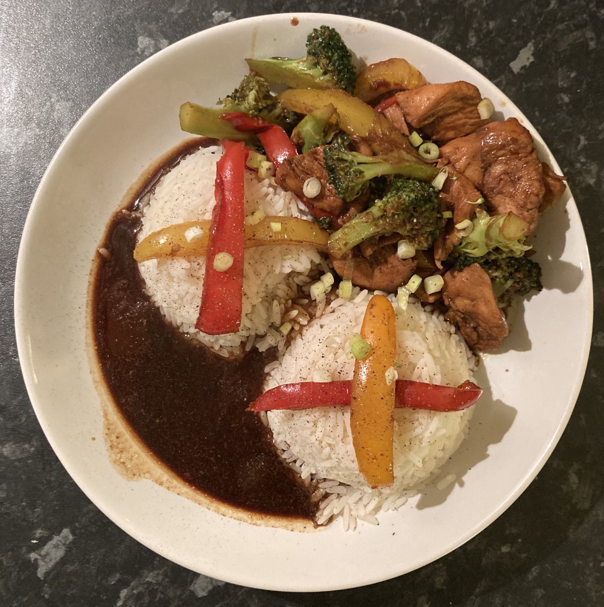 Non-vegan chicken slithers marinaded in dark soy sauce, ginger and garlic then stir fried with line caught peppers and free range broccoli sitting beside two heaving Dolly Parton white rice domes sprinkled with finely cut springy onions #Mmmmm