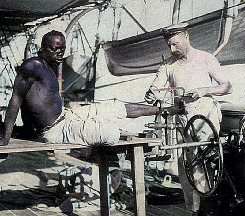 AfricanArchives's tweet photo. A British blacksmith removing the leg irons off a slave, 1907. https://t.co/XkP6kMCelt
