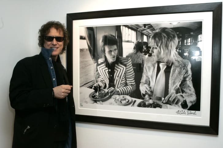 Mick Rock con una de sus fotografías a David Bowie