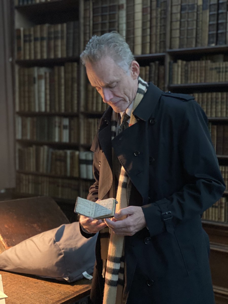 Holding an Isaac Newton notebook in the Wren Library at Trinity College Cambridge.