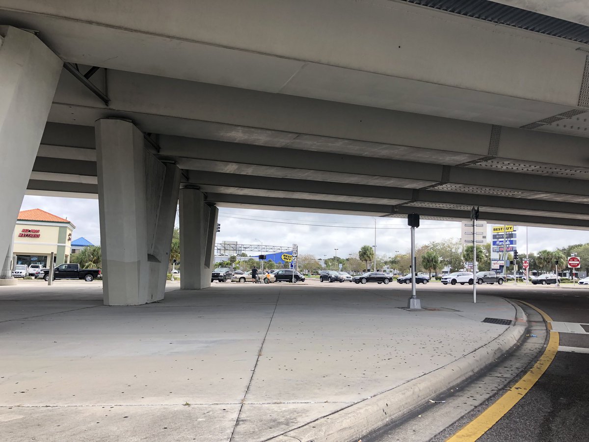 Whitbone's tweet photo. Just a father and son riding their bikes on #DrewStreet underneath #US19 in #ClearwaterFL. A programmed resurfacing project from here to #SunsetPointRoad needs to make the US19 frontage roads safer and accessible for everyone. @MyFDOT_Tampa @MyClearwater @PinellasCoNews https://t.co/VOYkZfyQtE