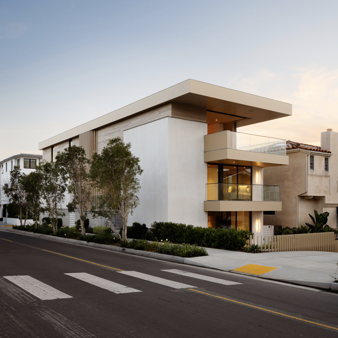 Raked plaster volumes shield the home from the noise of the street while the prominent wood slabs frame panoramic views towards the ocean. 
#LaneyLAinc #architecture #architect #manhattanbeach #ca #losangeles #elevation #facade #building #wood #woodceiling #view #residential