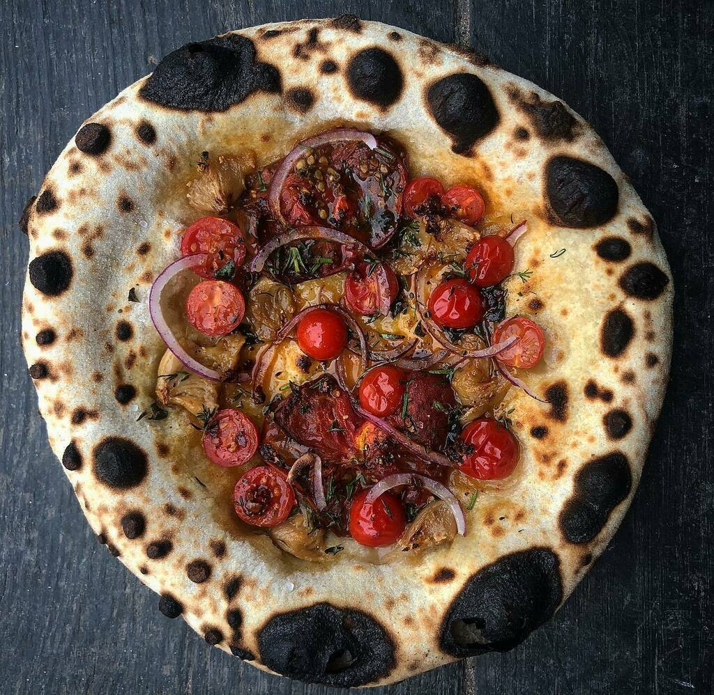 Flatbread goals. Confit tomatoes, confit garlic, red onion &amp; thyme. Light sprinkling of Aleppo chilli flake. Some anchovies on here wouldn’t go amiss either. 🔥@carmelrestaurantldn 
.
.
.

#flatbread #berberandq #newopening #launch #restaurant #restau… instagr.am/p/CWlKsDhoFrI/
