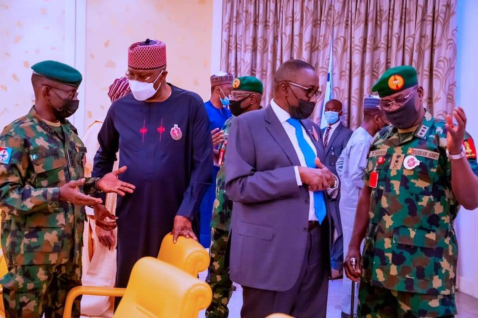 HotnewsN's tweet photo. Security Council 10: President Buhari with Vice President Prof. Yemi Osinbajo while decorating Col. YM Dodo (Aide de Camp to the President) to his new rank of Colonel shortly before presiding over Security Council Meeting in State House on 25th Nov 2021. With them is his wife. https://t.co/iibe8IQi0n