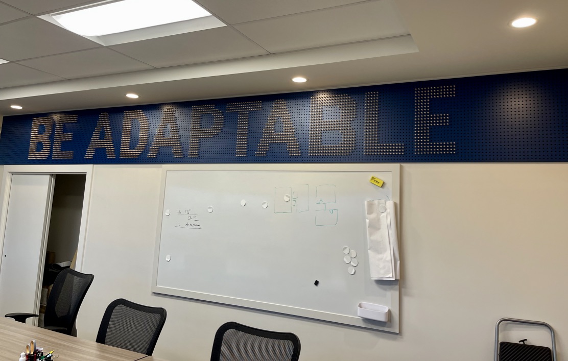 A #sign of the times. #BeAdaptable!  A #motivational wooden display board at #DiverseProperties HQ. Precision drilled holes and tapered wooden dowels individually inserted to create the stippled 3D lettering—a fun project to install. #fastsignscoqutilam #3dsigns