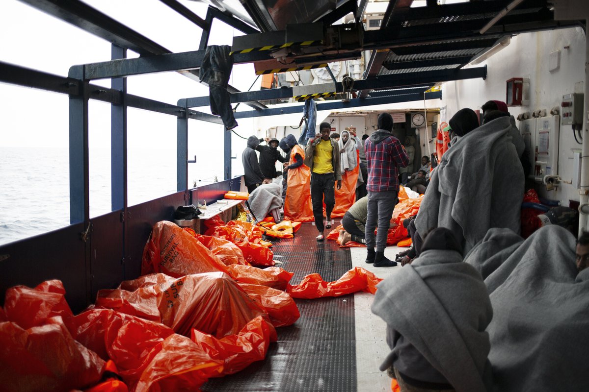 A photo of guests onboard who try to protect themselves with plastic bags and blankets from the weather