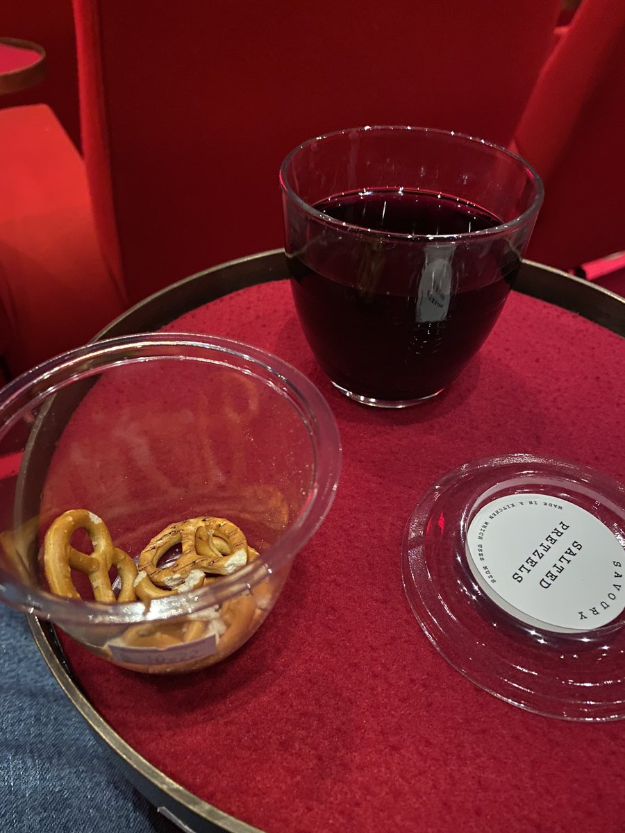 spanko58's tweet photo. About to watch House of Gucci. Pretzels and a rather nice Malbec in this cinema. #doitinstyle. https://t.co/OYyPeUI6UD
