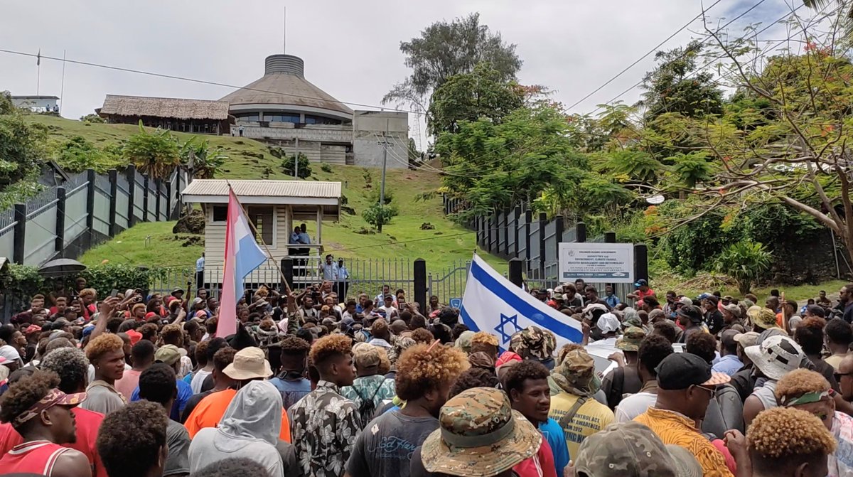 vijayprashad's tweet photo. When Sogavare's government shifted his country's link to China, the US - driven by @marcorubio and other violators of international sovereignty - built a coalition of anti-communists and pro-Zionist Christians. See the Israeli flag held by those making the coup. https://t.co/Czpwkuug60