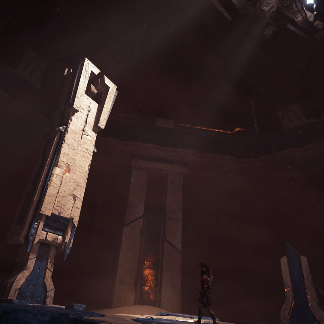 A Spartan soldier is exploring the ruins of an ancient Temple. 
On the left, a few rays of sunshine pass through the destroyed ceiling, illuminating a giant grey and blue pillar made of unknown materials. Its architecture is futuristic. 
On the right, what might have been a similar pilar is almost completely destroyed. 
In the background lies a blocked gate. 