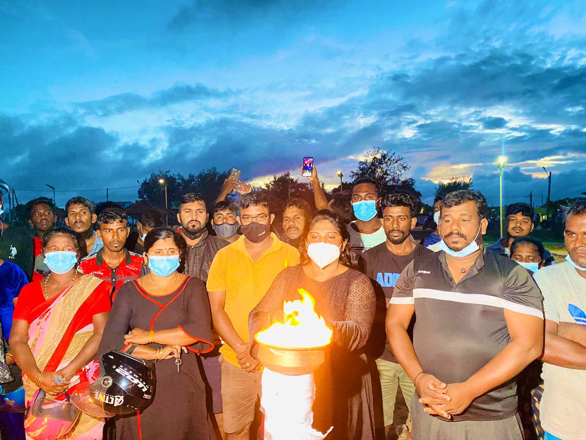 JDSLanka's tweet photo. In a show of resilience &amp; courage, Ilancheliyan Binduja lights the memorial flame in memory of fallen #Tamil militants on the #Mullaithivu seafront, despite #SriLanka police arresting her husband Peter Ilancheliyan while on their way to take part in Tamil Heroes Day event. https://t.co/FptbJ36PlO