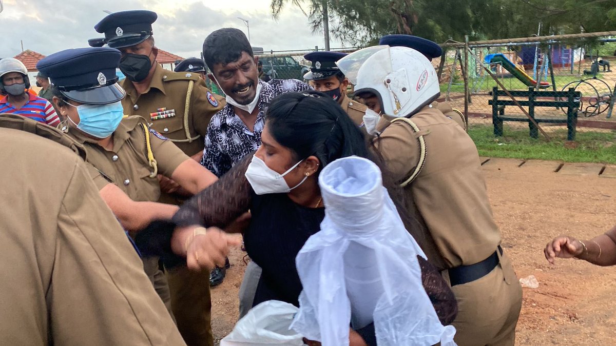 JDSLanka's tweet photo. In a show of resilience &amp; courage, Ilancheliyan Binduja lights the memorial flame in memory of fallen #Tamil militants on the #Mullaithivu seafront, despite #SriLanka police arresting her husband Peter Ilancheliyan while on their way to take part in Tamil Heroes Day event. https://t.co/FptbJ36PlO