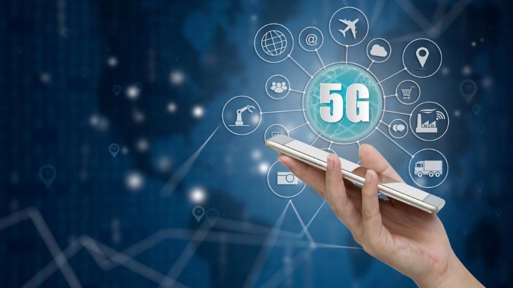 Kuvassa kännykkä ja 5G sekä palveluita ikoneissa.