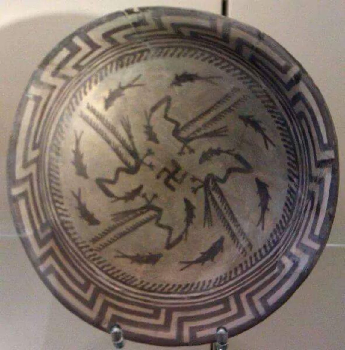 الصليب المعقوف دائمآ ما يذكرنا هذا الاسم بالحزب النازي 
لكن الحقيقة ان النازية تبنت هذا الشعار و ان اصوله قديمه جدأ تعود الى عدة ثقافات شرقية منها بلاد الرافدين حيث كان يرمز الى الخلود و الأزلية ويعد صحن سامراء من 5000 ق.م احد اقدم الدلائل الاثارية لهذا الرمز