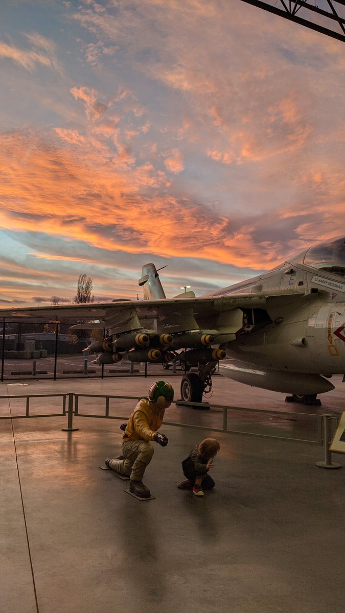 natalie_sly's tweet photo. My 2yo in his happy place (Boeing flight museum), doing his naval carrier flight deck catapult officer (aka "shooter") pose under a PNW sunset. This kid is a rocket/airplane fiend. 👨‍🚀 @NASA @museumofflight https://t.co/92rE6WPL9q