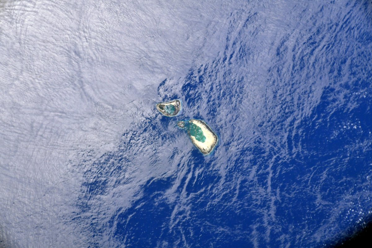 astromarshburn's tweet photo. The Earth surprised us with this jewel: an atoll in the Arabian Sea surrounded by glint from the mid-day sun. https://t.co/WFj6W7p9uk