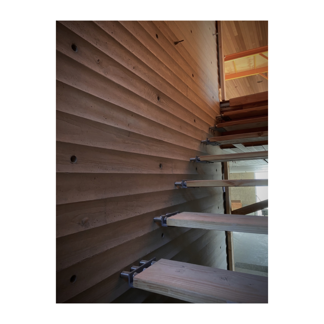 The scalloped concrete wall provides the structure for the floating oak stair. Two steel rods support each tread, while a third rod is hollow to provide power to the LED light concealed in each element. #LaneyLAinc #architecture #architect #design #designer #manhattanbeach #ca