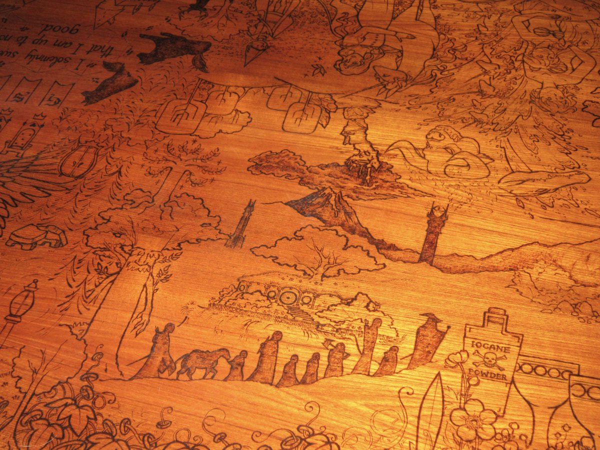 TheGildedOak's tweet photo. My biggest pyrography commission is FINISHED! There are 8 panels burned into the top of a dining room table, each featuring the clients' favorite fantasy series from when they were younger.  1/5 https://t.co/J9qF9heA2d