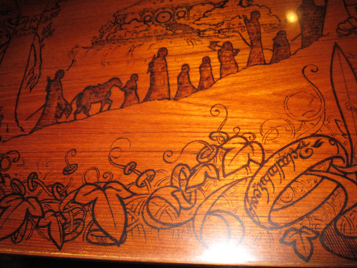 TheGildedOak's tweet photo. My biggest pyrography commission is FINISHED! There are 8 panels burned into the top of a dining room table, each featuring the clients' favorite fantasy series from when they were younger.  1/5 https://t.co/J9qF9heA2d
