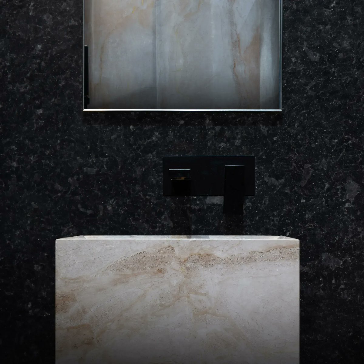 Contrasting light and dark stone can create a high end luxury spa feel!  The Angola Black granite wall has intensity and textures that are bought to life with subtle lighting.  The Daino Reale Marble sink feels monolithic in shape but also has a warmth and softness to it.